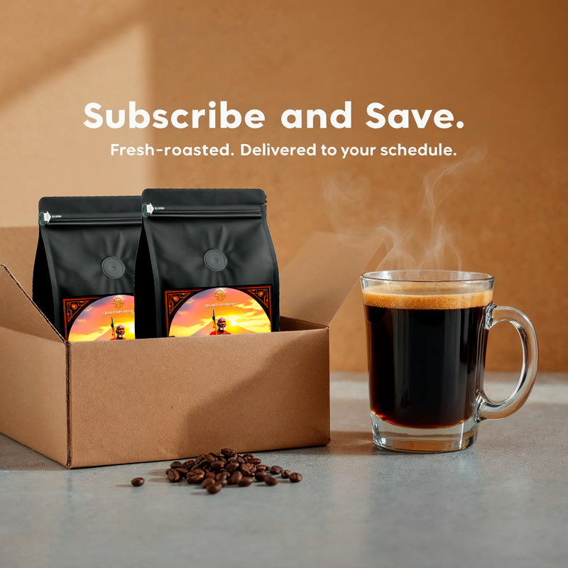 Cardboard box with Quantum Brew coffee bags and a glass of black coffee on a table.
